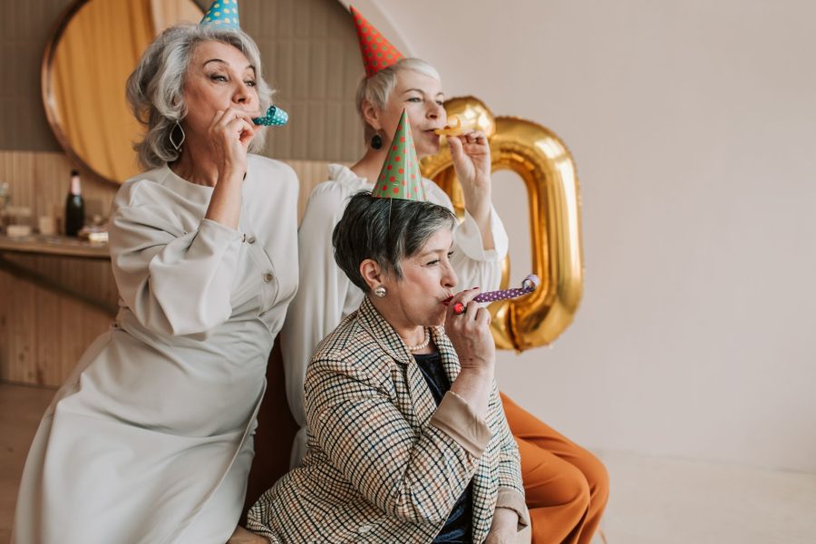 photo of elderly women blowing party blowers