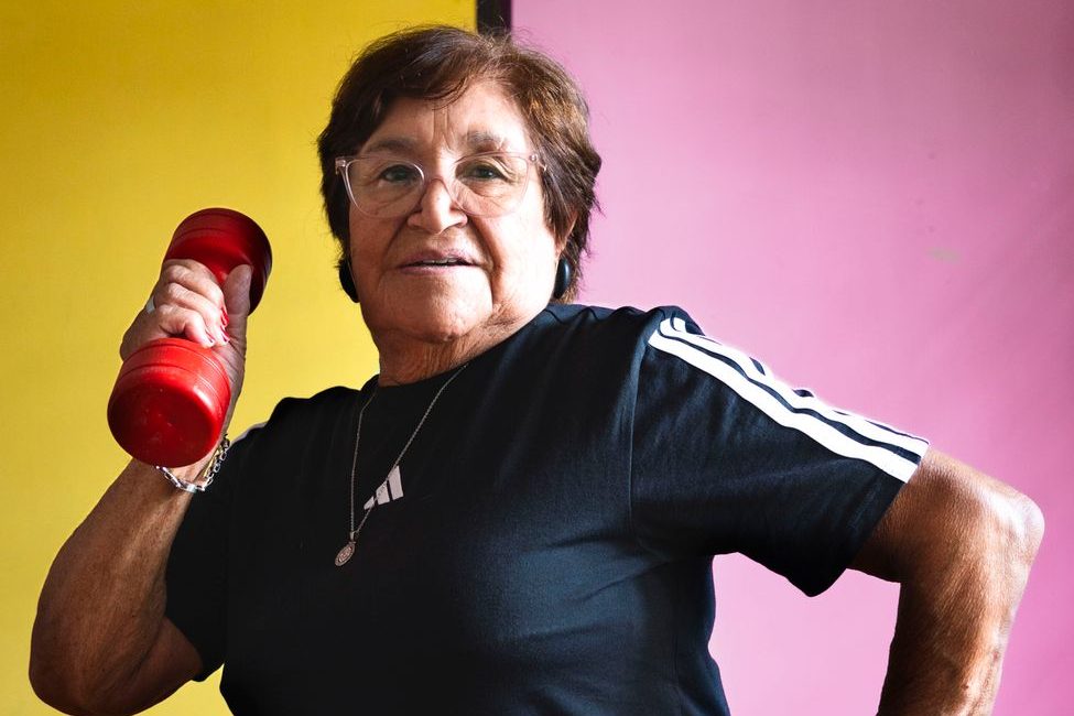 senior woman exercising with dumbbell at home